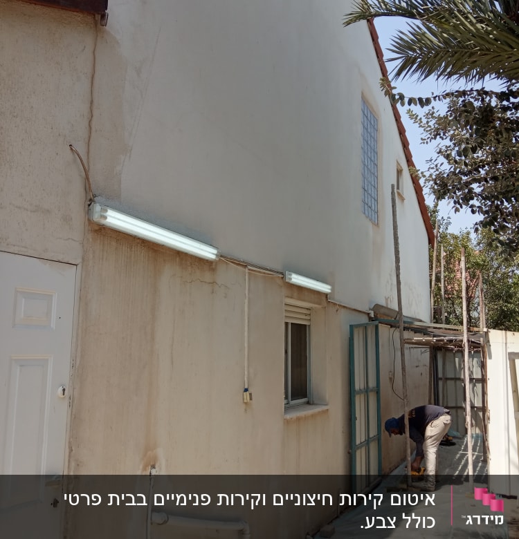 אדם עובד על איטום קיר חיצוני עם יריעות פלסטיק